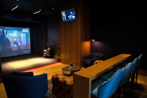 a room with a table and chairs and a projection screen at Four Seasons St. Louis in Saint Louis