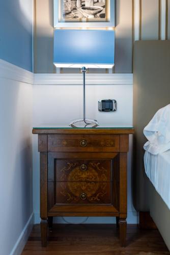 a nightstand with a lamp on it next to a bed at Palazzo Turchini in Naples