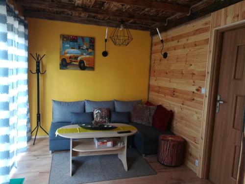 a living room with a blue couch and a table at Dolina Rosy in Ustrzyki Dolne