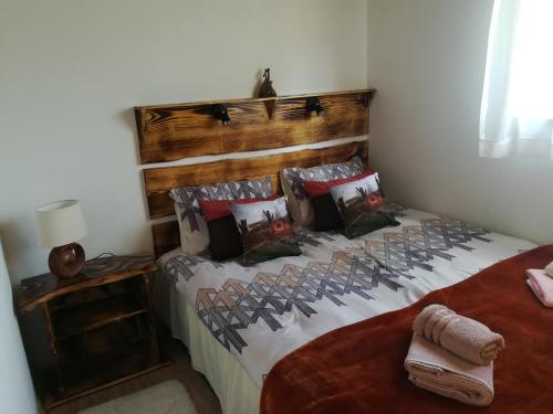 a bedroom with a bed with a wooden headboard and pillows at Dolina Rosy in Ustrzyki Dolne