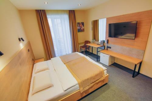 a bedroom with a bed and a desk and a television at Sport Hotel 1 in Cherkasy
