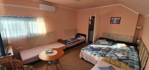 ベーラパットファールヴァにあるViola Apartmanのベッド2台とテーブルが備わる小さな客室です。