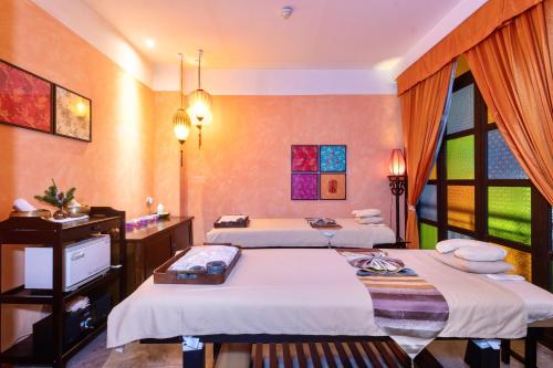 a hotel room with two beds and a window at Shanghai Mansion Bangkok in Bangkok