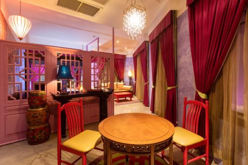a dining room with red curtains and a table and chairs at Shanghai Mansion Bangkok in Bangkok