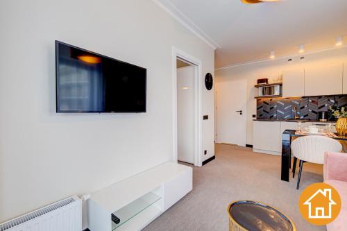 a living room with a tv on a wall at Apartamenty ApartPark - visitopl in Świnoujście