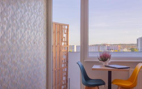 um quarto com uma mesa e duas cadeiras e uma janela em INITIUM rooms - Pokoje na wynajem - Obrońców Wybrzeża 4D em Gdansk
