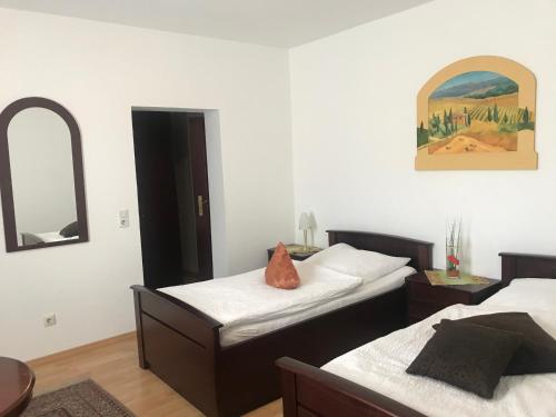 a bedroom with two beds and a mirror on the wall at Hotel-Restaurant Kranefoer in Waltrop