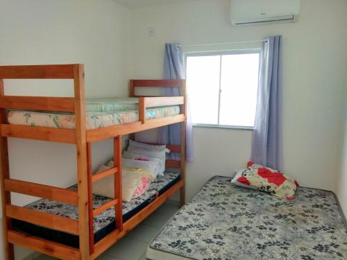 a bedroom with two bunk beds and a window at Residencial Mar Da Galileia in Porto Seguro