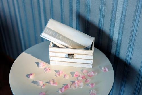 a small box with a book and butterflies on a plate at Hotel Bellevue in Gardone Riviera