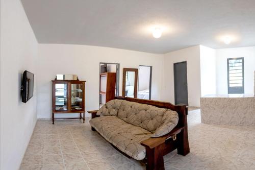 Hotel Fazenda Colina dos Sonhos في سوكورو: غرفة معيشة مع أريكة وتلفزيون