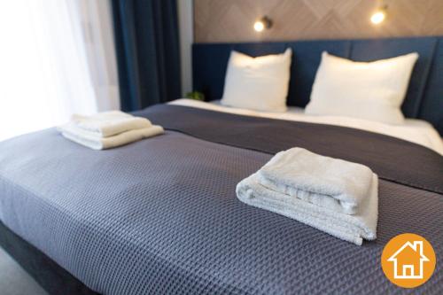 a bedroom with two beds with towels on them at Apartamenty ApartPark - visitopl in Świnoujście