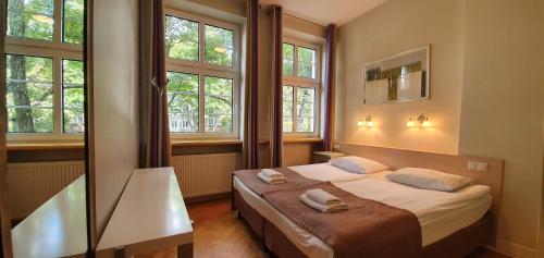 a bedroom with a bed with two towels on it at Patio Apartments - Old Town in Gdańsk