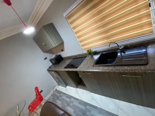 a small kitchen with a sink and a window at Bonsukoda Lodge in Accra