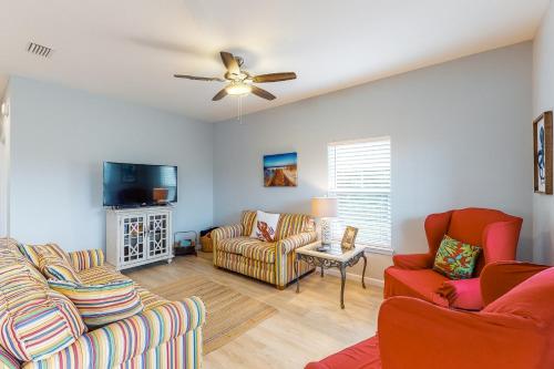 a living room with two couches and a ceiling fan at Knot a Care in Mexico Beach