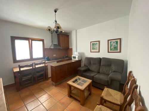 a living room with a couch and a kitchen at Arco - Virgen Apartamentos y Habitación in Conil de la Frontera