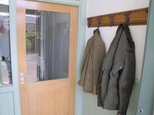 Una puerta con dos chaquetas colgando al lado. en Bankhouse B&B en Aberlour