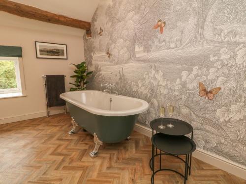 a bathroom with a large bath tub and butterflies on the wall at Overlea Cottage in Highpeak Junction