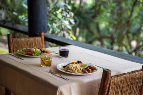 uma mesa com dois pratos de comida e bebidas em Hotel Fazenda Parque dos Sonhos em Socorro