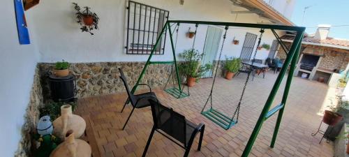 a patio with a swing set in a house at Vivienda rural casa manoli 