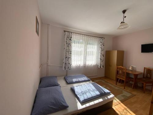 a bedroom with a bed and a table and a window at Noclegi "Na Szczyrboku" Dom I in Korbielów