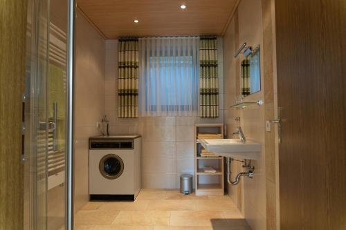 a bathroom with a washing machine and a sink at Ferienwohnung Andrea in Riedenburg