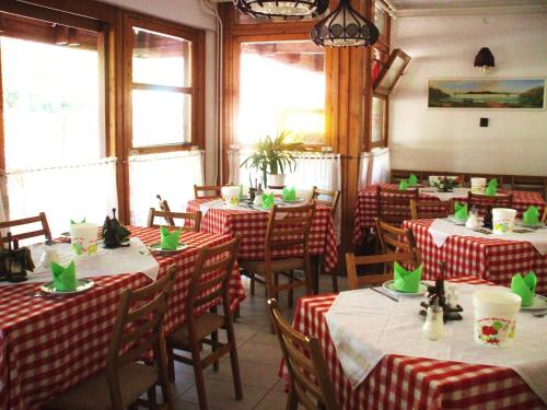 a restaurant with red and white clothed tables with green napkins at Oleander B&B in Siófok