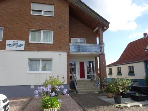 a brick house with a porch and stairs at Miramar in Dahme