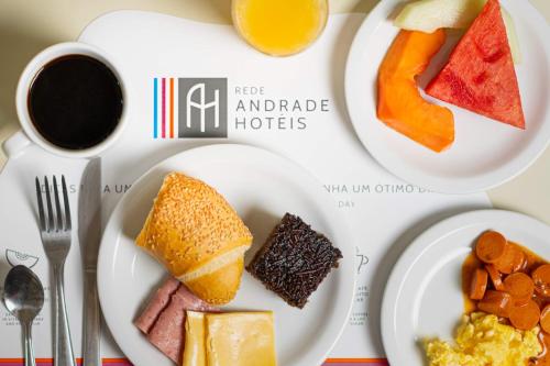 a table with three plates of food and a cup of coffee at Rede Andrade Riviera Premium in Salvador