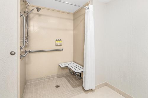 a walk in shower with a bench in a bathroom at Holiday Inn Express & Suites Wilmington-Newark by IHG in Newark