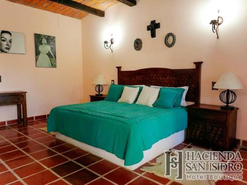 a bedroom with a bed and a cross on the wall at Hotel Hacienda San Isidro in San Isidro Mazatepec