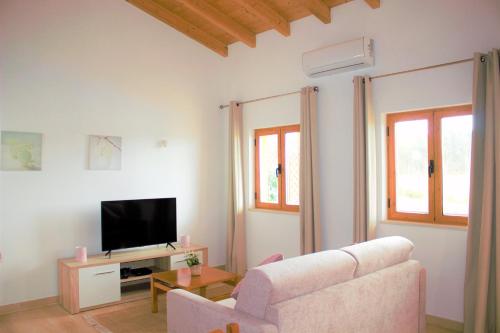 a living room with a couch and a tv at Quinta das Alfambras in Aljezur