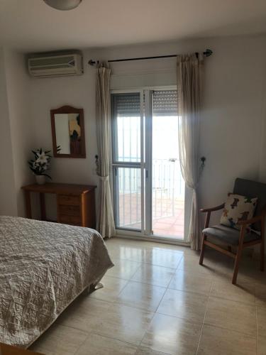 a bedroom with a bed and a chair and a sliding glass door at Casa Darwin in San José