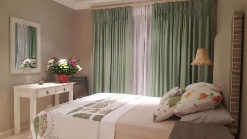 a bedroom with a bed and a dresser and a window at The Haven in Jongensfontein