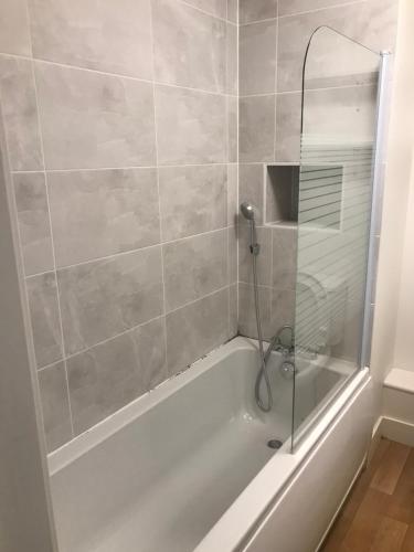 a bathroom with a tub with a glass shower at YBC Court, Aldershot in Aldershot