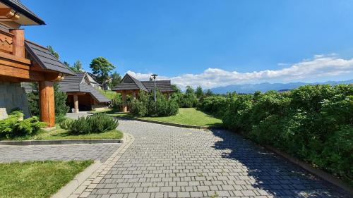 a cobblestone path in a garden with houses at Apartament z Widokiem in Gliczarów