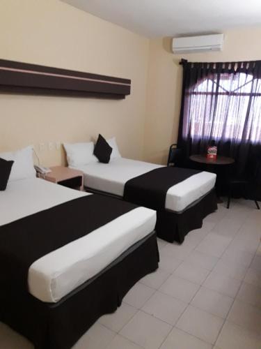 En eller flere senger på et rom på Hotel Miramar Inn