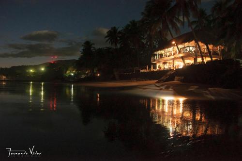 a building on the shore of a lake at night at Olas Permanentes El Zonte in El Zonte