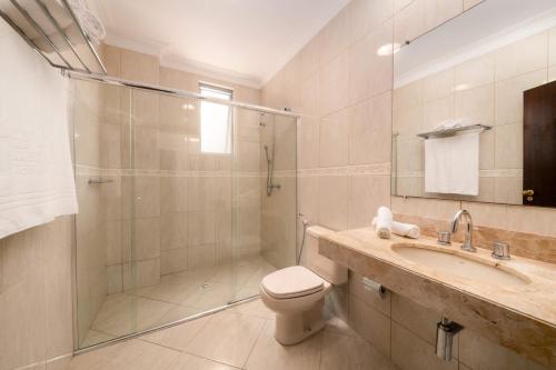 y baño con ducha, aseo y lavamanos. en Rede Andrade Hangar, en Belém