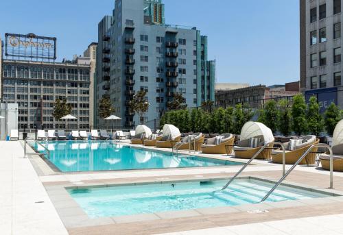 a large swimming pool with lounge chairs and a building at Level Los Angeles - Downtown South Olive in Los Angeles