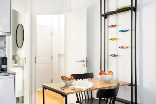 uma sala de jantar com mesa e cadeiras e uma cozinha em FLH Vila Rosário Cosy Flat II em Lisboa