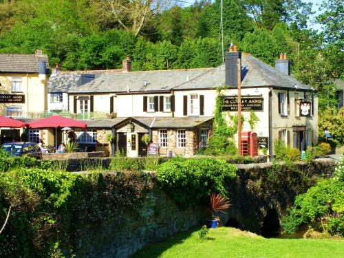 une auberge avec un mur en pierre devant elle dans l'établissement The Copley Arms, à East Looe