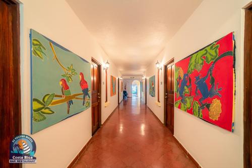 a corridor in a building with paintings on the walls at Hotel El Velero in Playa Hermosa