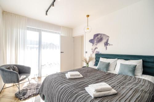 ein Schlafzimmer mit einem großen Bett mit zwei Handtüchern darauf in der Unterkunft Stylish Apartment Balticus 15 with Air Conditioning by Noclegi Renters in Misdroy