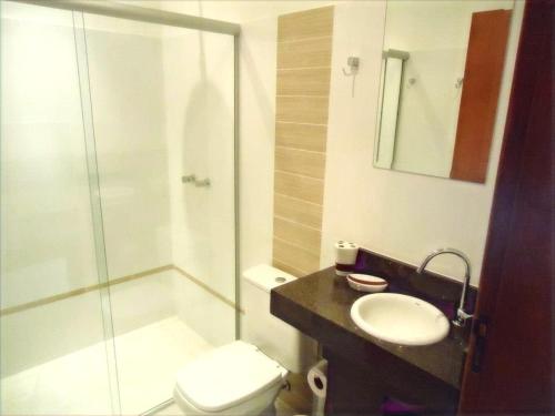uma casa de banho com um chuveiro, um WC e um lavatório. em Prime Hotel Hortolândia em Hortolândia
