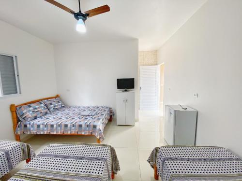 a room with two beds and a tv in it at Pousada LM in Nova América da Colina