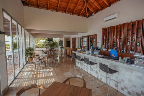 a restaurant with a bar with tables and chairs at La Amada condo with Marina View in Cancún