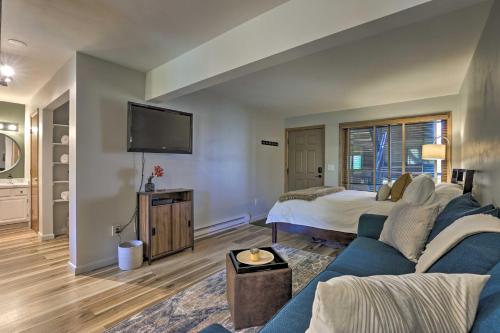 a living room with a blue couch and a bed at Steamboat Springs Studio Less Than 1 Mi to Ski Resort in Steamboat Springs