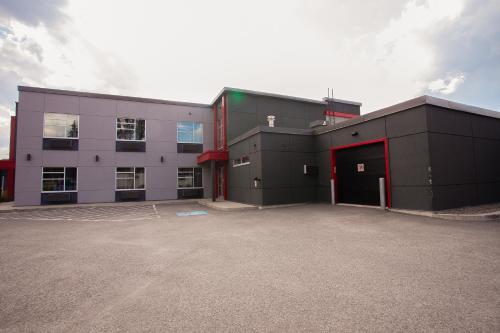 a large building with a parking lot in front of it at Motel Newstar Laval in Laval