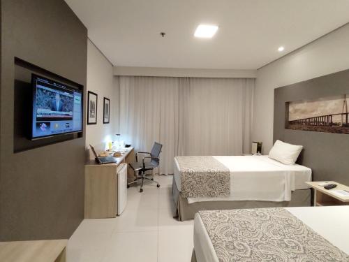 a hotel room with two beds and a flat screen tv at TRYP by Wyndham Manaus Aeroporto in Manaus