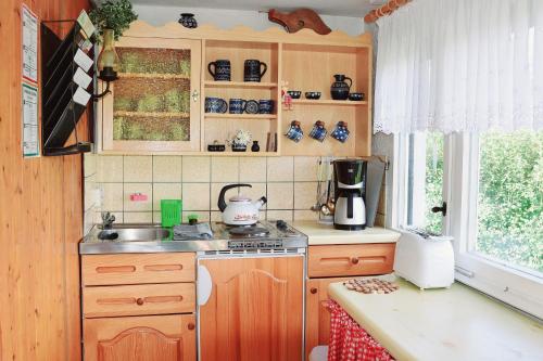 a kitchen with a sink and a stove and a window at Talblick 2 - Ihr Zuhause : das Ferienhaus mitten im idyllischen Tal in Bad Bibra